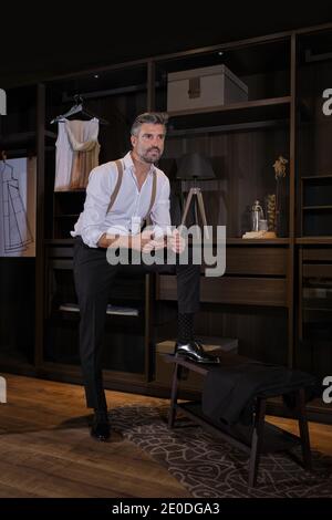 Stock photo of elegant business man wearing suit using his mobile phone. Stock Photo