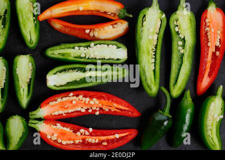 Ripe homegrown red and green jalapeno chilli peppers exposed to reveal seeds and membranes. UK Stock Photo