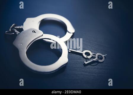 Handcuffs on wooden background. Crime and violence concept. Stock Photo