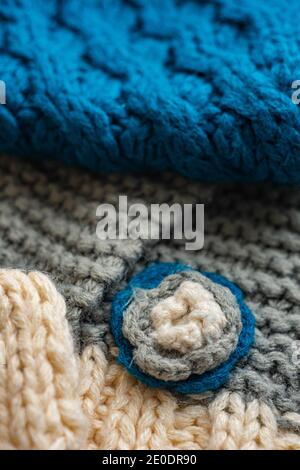 Knitted pattern of threads of two colors and styles. Small flower on knitted cloth Stock Photo