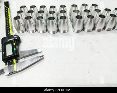 vernier caliper and some aluminum pieces on a white table Stock Photo