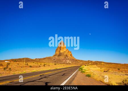 The rugged peaks of Agathla Peak (also known as El Capitan) towering over the desert landscape south of Monument Valley along Highway US Route 163 in Stock Photo