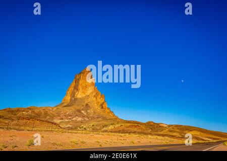 The rugged peaks of Agathla Peak (also known as El Capitan) towering over the desert landscape south of Monument Valley along Highway US Route 163 in Stock Photo