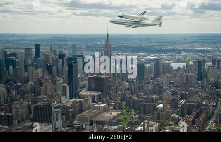 Space shuttle Enterprise, mounted atop a NASA 747 Shuttle Carrier Aircraft (SCA), is seen as it flies near the Empire State Building, Friday, April 27, 2012, in New York. Enterprise was the first shuttle orbiter built for NASA performing test flights in the atmosphere and was incapable of spaceflight. Originally housed at the Smithsonian's Steven F. Udvar-Hazy Center, Enterprise will be demated from the SCA and placed on a barge that will eventually be moved by tugboat up the Hudson River to the Intrepid Sea, Air & Space Museum in June. Photo by Robert Markowitz/Nasa via ABACAPRESS.COM Stock Photo