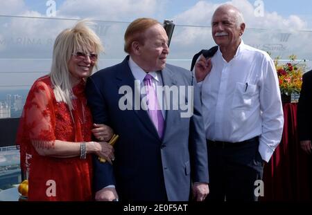 American business magnate, Chairman and CEO Las Vegas Sands Corporation, Sheldon Adelson (C) and Israeli-born architect Moshe Safdie (R) at Marina Bay Sands Resort in Singapore in 2010. Developed by Las Vegas Sands, it is billed as the world's most expensive standalone casino property at S billion, including cost of the prime land. The resort features a 2,561-room hotel, a 120,000 m2 convention-exhibition centre, the 74,000 m2 The Shoppes at Marina Bay Sands mall, a museum, two large theatres, seven celebrity chef restaurants, two floating Crystal Pavilions, an ice skating rink, and the world' Stock Photo