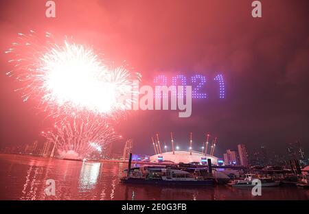 Fireworks and drones illuminate the night sky over London as they form a light display as London's normal New Year's Eve fireworks display was cancelled due to the coronavirus pandemic. Stock Photo