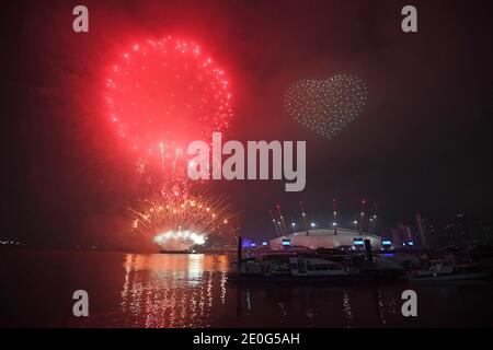 Fireworks and drones illuminate the night sky over London as they form a light display as London's normal New Year's Eve fireworks display was cancelled due to the coronavirus pandemic. Stock Photo