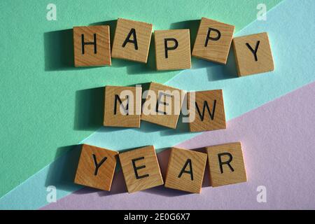 Happy New Year, words in wooden alphabet letters isolated on colourful background Stock Photo