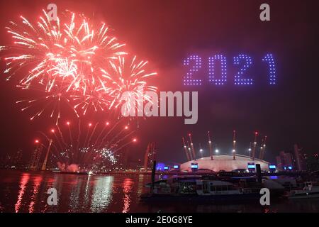 Fireworks and drones illuminate the night sky over London as they form a light display as London's normal New Year's Eve fireworks display was cancelled due to the coronavirus pandemic. Stock Photo