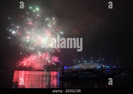 Fireworks and drones illuminate the night sky over London as they form a light display as London's normal New Year's Eve fireworks display was cancelled due to the coronavirus pandemic. Stock Photo