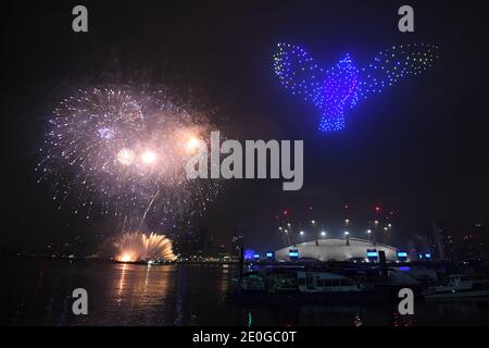 Fireworks and drones illuminate the night sky over London as they form a light display as London's normal New Year's Eve fireworks display was cancelled due to the coronavirus pandemic. Stock Photo