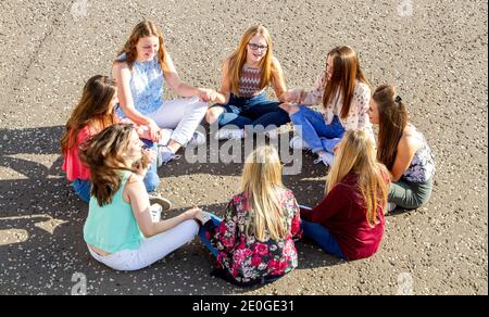 Eight beautiful teenage girls spend time together having fun and enjoying the glorious warm sunny weather along Broughty Ferry beach near Dundee during the 2015 October school holidays in  Scotland, UK