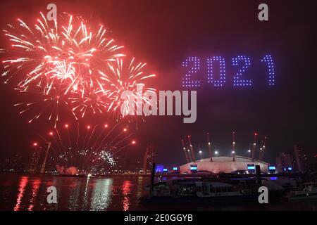 Fireworks and drones illuminate the night sky over the The O2 in London as they form a light display as London's normal New Year's Eve fireworks display was cancelled due to the coronavirus pandemic. Stock Photo