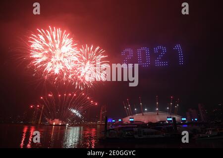 Fireworks and drones illuminate the night sky over the The O2 in London as they form a light display as London's normal New Year's Eve fireworks display was cancelled due to the coronavirus pandemic. Stock Photo