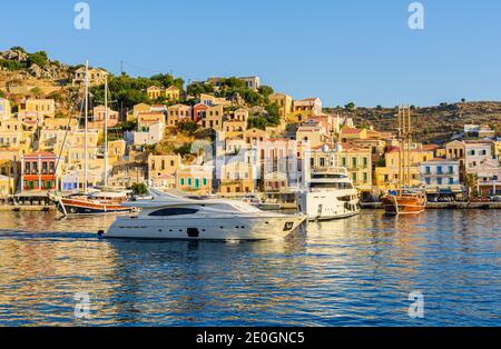 Luxury boats in the harbour of Yialos Town, on the island of Symi, Greece Stock Photo