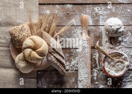 bread with wheat ears and flour on wood board, top view Stock Photo