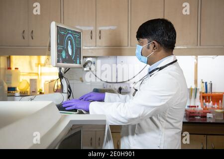 male doctor using advance scanning machine computer at hospital. Practitioner working on modern medical equipment. Digital diagnostics, heart disease Stock Photo