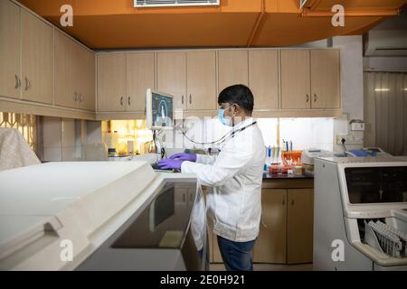 male doctor using advance scanning machine computer at hospital. Practitioner working on modern medical equipment. Digital diagnostics, heart disease Stock Photo