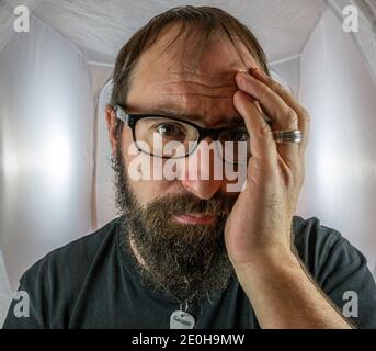 A bearded sad looking man in a depressive mood Stock Photo