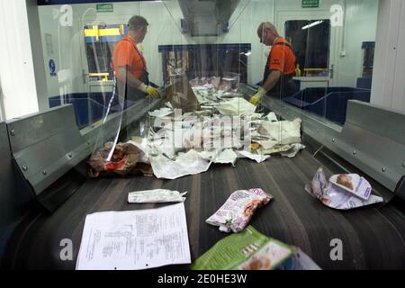 Cracow. Krakow. Poland. Waste recycling plant. Workers manualy select and sort garbage that travels on a conveyor belt. Stock Photo