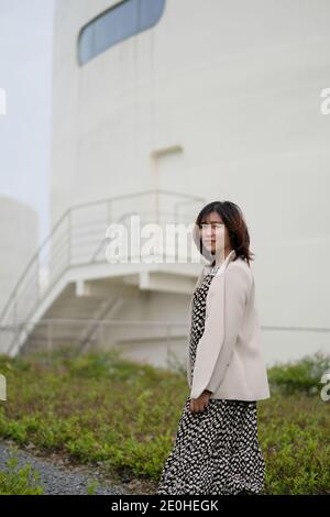 mid shot of one beautiful Asian young lady, smiling at camera outdoor Stock Photo