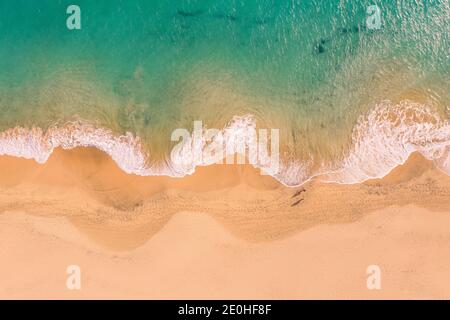 Aerial top down view of beautiful Atlantic ocean coast with crystal clear turquoise water and sandy beach, waves rolling into the shore