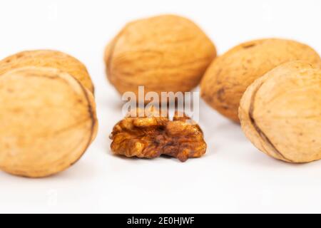 shelled walnuts and walnuts in shell on white background Stock Photo