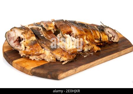 smoked fish, cut into pieces on a wooden cutting board Stock Photo