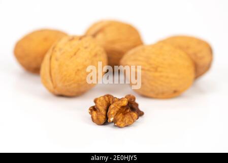 shelled walnuts and walnuts in shell on white background Stock Photo
