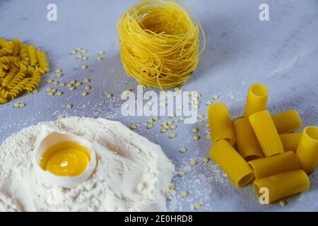 ingredients for homemade pasta. Food background: macaroni, spagetti, egg, flour Stock Photo