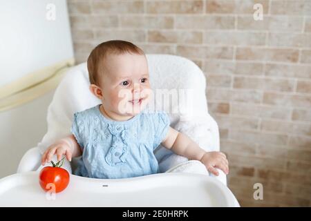 Cute child little girl eating healthy food in kindergarten. baby in chair. copy space Stock Photo