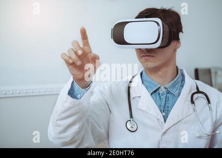 Close up of a male doctor wearing 3d vr glasses. Experienced male doctor using modern technology at work, wearing virtual reality 3d headset. Future, Stock Photo
