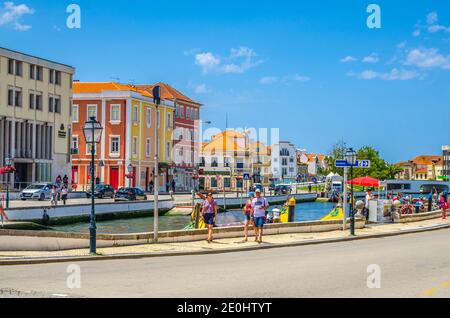 Aveiro, Portugal, June 13, 2017: people tourists walking down embankment promenade near narrow water canal and typical colorful buildings in Aveiro hi Stock Photo