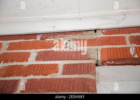 Cracked seals between the bricks above a door Stock Photo