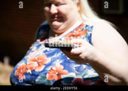 Albino woman holding a black gift box with a golden bow Stock Photo