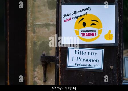 Coburg, Germany. 01st Jan, 2021. In front of a shop there is a sign saying 'Be responsible'. The city of Coburg has tightened its Corona regulations due to further increasing infection figures. From this Thursday (31.12.2020) onwards, only two specifically named households with a maximum of five adults are allowed to visit each other. Credit: Nicolas Armer/dpa/Alamy Live News Stock Photo