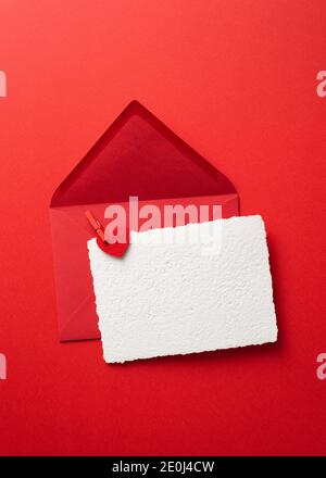 Valentines Day greeting card mockup in envelope on a red background with hearts Stock Photo