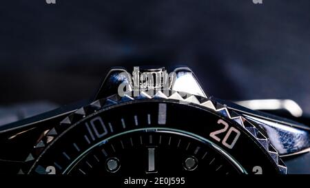 Close-up of the crown of a black and chrome colored mens wristwatch. Stock Photo