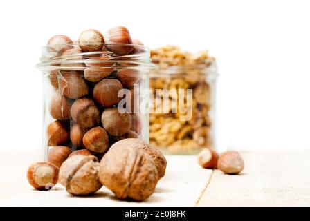 Jar of hazelnuts, with jar of walnuts in the background Stock Photo