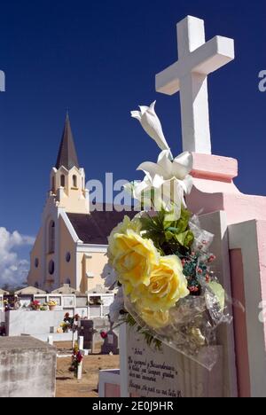 Flowers decorate crypts in the cemetery next to the historic and colorful St. Anna's Catholic Church, Noord, Aruba.