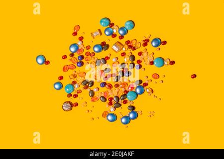Multi coloured beads on yellow background Stock Photo