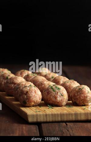 Fresh raw meat balls isolated on wooden table. Copy space. Stock Photo