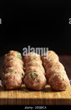 Fresh raw meat balls isolated on wooden table. Copy space. Stock Photo