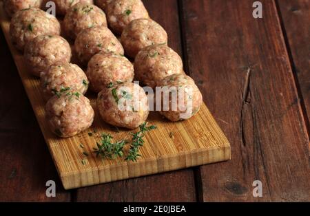 Fresh raw meat balls isolated on wooden table. Copy space. Stock Photo