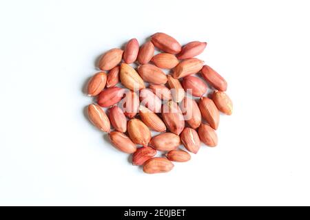 Red peanuts in husk. Pile of unpeeled nuts isolated on white background Stock Photo