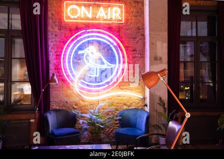 15 December 2020, St. Petersburg Russia. Seagull bird made of neon colorful light on brick wall in radio station room. Stock Photo