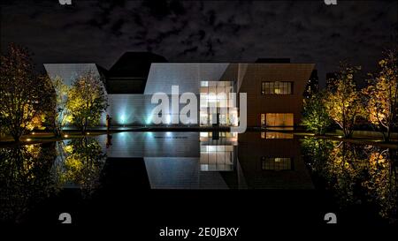 Modern building exterior in Toronto, Ontario, Canada at night with reflection in water