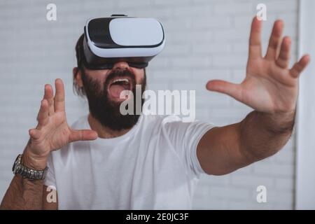 Mature bearded businessman screaming in excitement using virtual reality 3d headset. Expressive businessman trying vr glasses at work, copy space Stock Photo