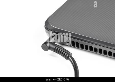 Electricity charging black laptop isolated on white background. Closeup Stock Photo