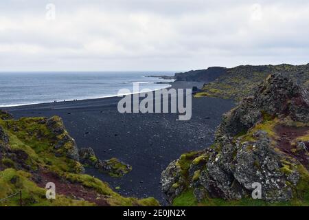 Djúpalónssandur, a black sand beach and bay on the Snaefellsnes Peninsular in Western Iceland.  Green moss covers the black lava rocks. Stock Photo